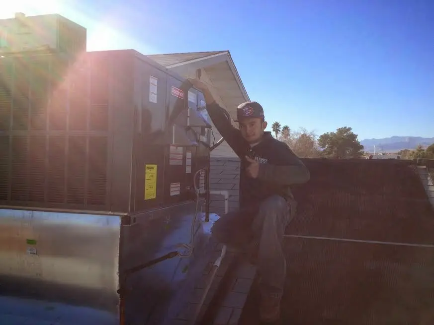 HVAC technician performing HVAC Inspection on a rooftop unit in Denton